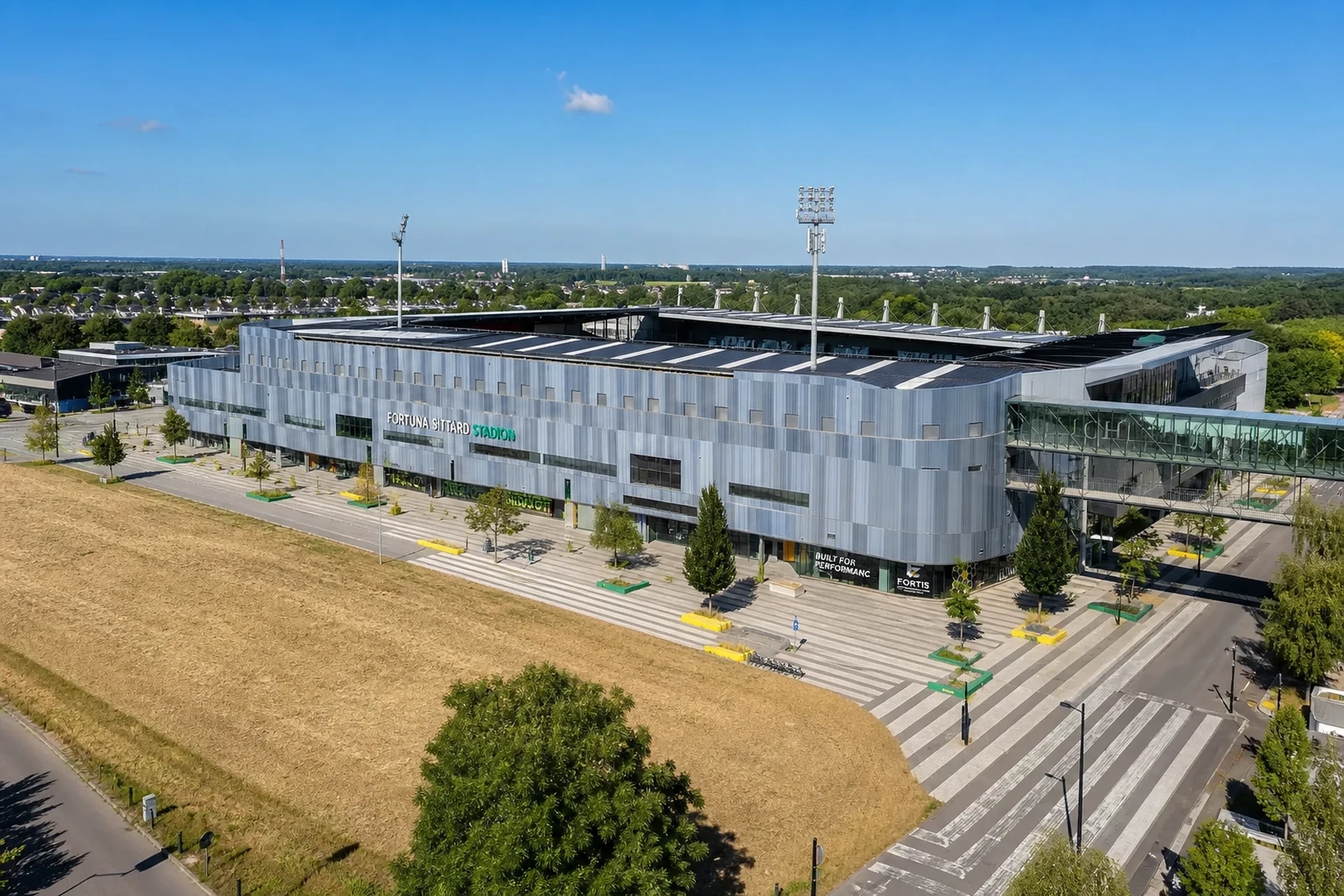 Groot parkeerterrein bij een stadion vanuit de lucht